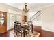 Dining room featuring wood floors, a wooden table, decorative rug, natural light, and wrought iron staircase in background at 3564 Brampton Dr., Myrtle Beach, SC 29588