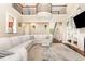 Bright living room featuring a large sectional sofa, hardwood floors, fireplace, and a wrought iron staircase and balcony at 3564 Brampton Dr., Myrtle Beach, SC 29588