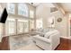 Bright and airy living room showcasing high ceilings, large windows, hardwood floors, a fireplace, and a modern sectional sofa at 3564 Brampton Dr., Myrtle Beach, SC 29588