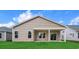 Backyard featuring a covered patio, green grass, and a house with tan siding under a cloudy sky at 367 Broughton Dr., Myrtle Beach, SC 29579