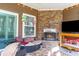 Cozy covered patio features a stone fireplace, comfortable seating, and natural light at 3672 White Wing Circle, Myrtle Beach, SC 29579