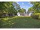 Spacious backyard featuring a well-kept lawn, trampoline, swing, and white house for recreational enjoyment at 3772 Brown Bark Ln., Murrells Inlet, SC 29576