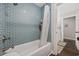 A bathtub with light blue subway tile, white shower curtain and fixtures for a calming bathroom experience at 3772 Brown Bark Ln., Murrells Inlet, SC 29576