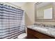 Bathroom showcasing granite vanity, framed mirror, toilet, and a striped shower curtain at 3926 Long Avenue Ext., Conway, SC 29527