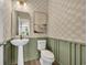 Stylish powder room with patterned wall, modern fixtures, and wainscoting at 402 Sun Colony Blvd., Longs, SC 29568