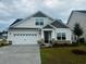 Charming single Gathering home featuring a two-car garage, stone accents, and covered porch at 4031 Bucolic Loop, Myrtle Beach, SC 29588