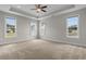 Spacious main bedroom featuring a tray ceiling, ceiling fan, neutral paint, and multiple windows at 4067 Ridgewood Dr., Conway, SC 29526