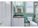 Well-lit bathroom with a stylish granite sink, toilet, and a shower with a decorative curtain at 4341 Grande Harbour Blvd., Little River, SC 29566