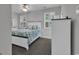 Comfortable bedroom with a ceiling fan, plush carpet, white wood trim, and two bright windows at 4341 Grande Harbour Blvd., Little River, SC 29566