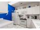 Bright kitchen featuring white cabinets, appliances, and a bold blue accent wall at 4429 Turtle Ln. # 3A, Little River, SC 29566