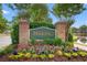 Community entrance sign surrounded by lush landscaping and colorful flowers welcoming residents and guests at 4429 Turtle Ln. # 3A, Little River, SC 29566