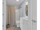 Bright bathroom featuring a shower with a striped curtain, vanity with storage, and neutral colored tile flooring at 4522 N Plantation Harbour Dr. # E-3, Little River, SC 29566