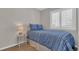 Cozy bedroom featuring a stylish blue patterned bedspread, a bedside table with lamp, and shuttered window at 4522 N Plantation Harbour Dr. # E-3, Little River, SC 29566