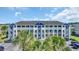 Beautiful condominium complex with blue and white trim accents surrounded by palm trees at 4522 N Plantation Harbour Dr. # E-3, Little River, SC 29566
