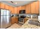Well-equipped kitchen featuring stainless steel appliances, granite counters, and wood cabinets at 4532 Girvan Dr. # A, Myrtle Beach, SC 29579