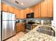 Kitchen featuring granite countertops, stainless steel appliances, and wooden cabinetry at 4532 Girvan Dr. # A, Myrtle Beach, SC 29579