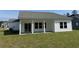 Home's backyard featuring a covered patio with sliding glass doors and a spacious grassy yard at 4750 N Huckleberry Ln., Conway, SC 29526