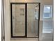 Walk-in shower showcasing marbled tiling with built-in shower shelves and a black-framed door at 4750 N Huckleberry Ln., Conway, SC 29526