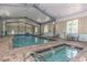 Bright indoor pool with spa, lounge chairs and tables for relaxing and socializing at 501 Maison Dr. # F8, Myrtle Beach, SC 29572