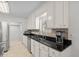 Bright kitchen offers black granite countertops, stainless appliances, and white cabinets at 527 Bay Drive Ext., Garden City Beach, SC 29576