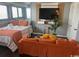 Comfortable living room with a queen bed, accented with orange throw pillows and a leafy plant at 5905 Ocean Blvd. S # 1608, Myrtle Beach, SC 29577