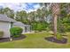Manicured backyard with lush greenery, mature trees, and a screened porch offers a private retreat at 5916 Falcon Landing Circle, North Myrtle Beach, SC 29582