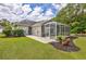 Expansive backyard with lush lawn, mature landscaping, and screened porch, perfect for outdoor enjoyment at 5916 Falcon Landing Circle, North Myrtle Beach, SC 29582