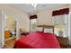 Bright bedroom with red bedding, a ceiling fan, and a window overlooking the outdoors at 5916 Falcon Landing Circle, North Myrtle Beach, SC 29582