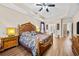 Spacious main bedroom showcasing wood floors, ceiling fan, tray ceilings, and access to the bathroom at 5916 Falcon Landing Circle, North Myrtle Beach, SC 29582