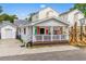 Charming beach house with a covered front porch, white siding, and red shutters at 6001- 5718 S Kings Highway, Myrtle Beach, SC 29575
