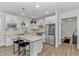 Open kitchen with white cabinetry, modern appliances, island seating, and wood flooring at 6076 Campanella St., Myrtle Beach, SC 29577