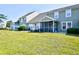 Exterior view of a home's backyard featuring a screened-in porch and well-maintained lawn at 6172 Catalina Dr. # 214, North Myrtle Beach, SC 29582