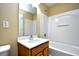Bathroom features white tiling, a shower-tub combo, and a vanity with a sink and wooden cabinets at 6172 Catalina Dr. # 214, North Myrtle Beach, SC 29582