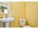 Cozy half bath with pedestal sink and toilet, accented by a round mirror at 6172 Catalina Dr. # 214, North Myrtle Beach, SC 29582