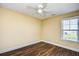 This bedroom features wood-look floors, a ceiling fan, and a window offering natural light at 6172 Catalina Dr. # 214, North Myrtle Beach, SC 29582