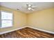 Bright bedroom offers wood-look floors, a ceiling fan, and a window providing views of the neighborhood at 6172 Catalina Dr. # 214, North Myrtle Beach, SC 29582