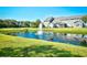 Scenic view of a neighborhood pond with a fountain and townhomes in the background on a sunny day at 6172 Catalina Dr. # 214, North Myrtle Beach, SC 29582