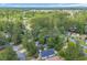 Aerial view of neighborhood with lake and scattered houses nestled between mature trees at 6612 Wintergreen Point, Myrtle Beach, SC 29588