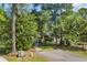 Quaint home surrounded by mature trees with a view of the driveway and front walkway at 6612 Wintergreen Point, Myrtle Beach, SC 29588