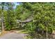 View of a cozy home nestled among mature trees with a paved walkway and driveway at 6612 Wintergreen Point, Myrtle Beach, SC 29588