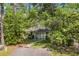 Cozy home surrounded by lush trees and greenery, complemented by a paved walkway and driveway at 6612 Wintergreen Point, Myrtle Beach, SC 29588