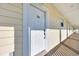 Condominium door entrance, with a white door, a door number, and exterior paneling at 683 Riverwalk Dr. # 302, Myrtle Beach, SC 29579