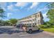 Attractive condominium building with outside staircases and parking on a sunny day at 683 Riverwalk Dr. # 302, Myrtle Beach, SC 29579