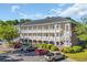 Condominium building with multiple levels, white balconies, and a parking area at 683 Riverwalk Dr. # 302, Myrtle Beach, SC 29579