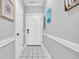 Condo hallway with white door, grey walls, and white tile flooring at 683 Riverwalk Dr. # 302, Myrtle Beach, SC 29579