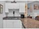 The kitchen bar has white cabinets, granite countertops, and a coffee maker for a cozy feel at 683 Riverwalk Dr. # 302, Myrtle Beach, SC 29579