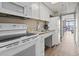 Galley kitchen with white appliances and cabinets leads to living area with ocean view at 6900 Ocean Blvd. # 935, Myrtle Beach, SC 29572