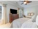 Bright bedroom featuring a ceiling fan, dark wood dresser with TV, and plantation shutters at 708 Ashland Ave., North Myrtle Beach, SC 29582