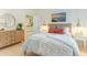 Cozy bedroom with a patterned quilt, wood dresser, round mirror, and stylish decor at 708 Ashland Ave., North Myrtle Beach, SC 29582