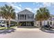 Charming coastal home featuring a screened porch, neutral siding, palm trees, and ample parking beneath at 708 Ashland Ave., North Myrtle Beach, SC 29582